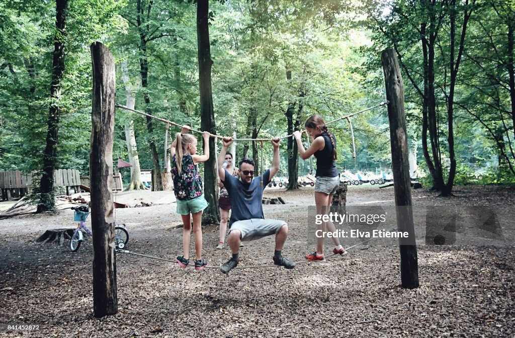 Forest Rope Balance Family Playing On A Balance Rope In A Forest Park High-Res Stock Photo ...