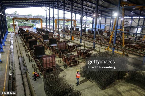 The steel reinforcing frames of precast concrete tunnel segments sits stacked near molds at the Mumbai Metro Rail Corp. Casting yard in Mumbai,...