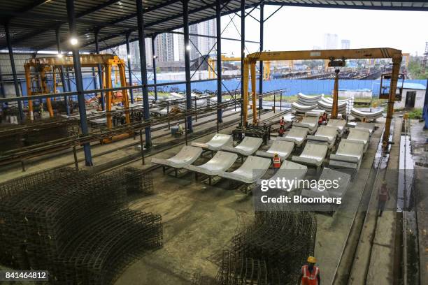 Precast concrete tunnel segments and steel reinforcing frames sit at the Mumbai Metro Rail Corp. Casting yard in Mumbai, India, on Monday, Aug. 28,...