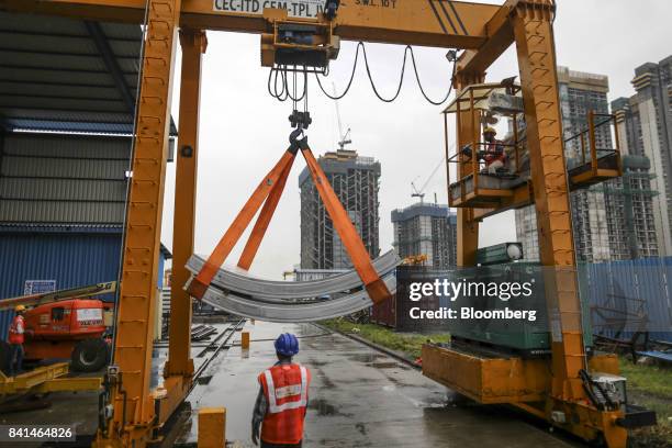 Precast concrete tunnel segments are maneuvered outside by crane at the Mumbai Metro Rail Corp. Casting yard in Mumbai, India, on Monday, Aug. 28,...