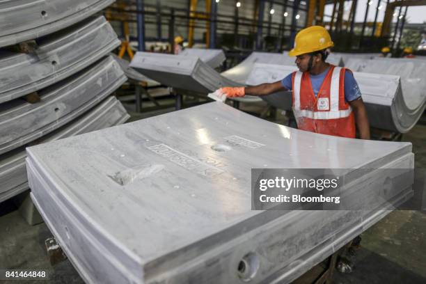 Worker checks a precast concrete tunnel segments sit at the Mumbai Metro Rail Corp. Casting yard in Mumbai, India, on Monday, Aug. 28, 2017. The...