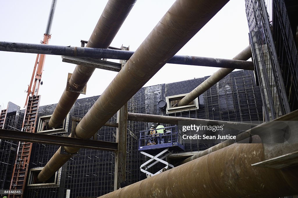 Ironworkers tieing rebar on foundation wall.