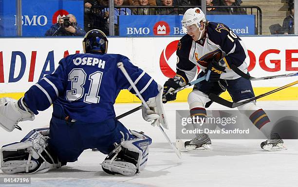 Curtis Joseph of the Toronto Maple Leafs slides into position as Bryan Little of the Atlanta Thrashers makes a move during their NHL game at the Air...