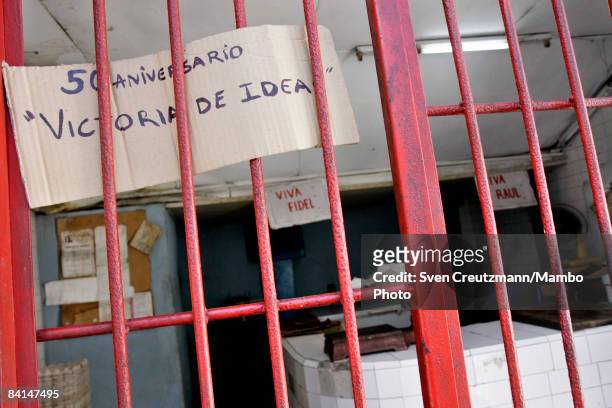 Cuban revolution propaganda hangs in the gate at a butcher�s shop which reads: 50th Anniversary; Victory of Ideas, and Long Live Fidel, and Long Live...