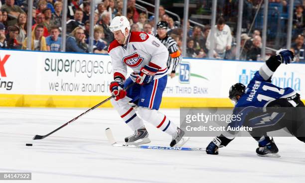 Mike Komisarek of the Montreal Canadiens controls the puck past Jeff Halpern of the Tampa Bay Lightning at the St. Pete Times Forum on December 30,...