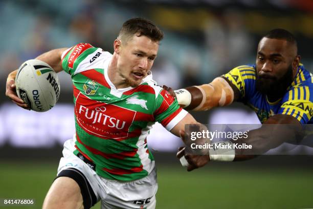 Damien Cook of the Rabbitohs beats the tackle of Semi Radradra of the Eels during the round 26 NRL match between the Parramatta Eels and the South...