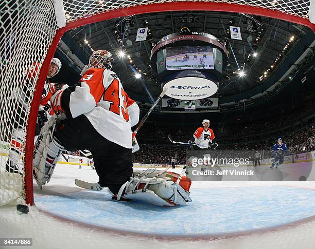 Martin Biron of the Philadelphia Flyers and teammates Kimmo Timonen and Mike Knuble stand dejected as the Canucks score during their game at General...