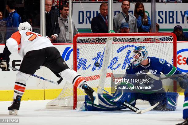 Curtis Sanford of the Vancouver Canucks looks over his shoulder after making a save on off Mike Knuble of the Philadelphia Flyers during their game...