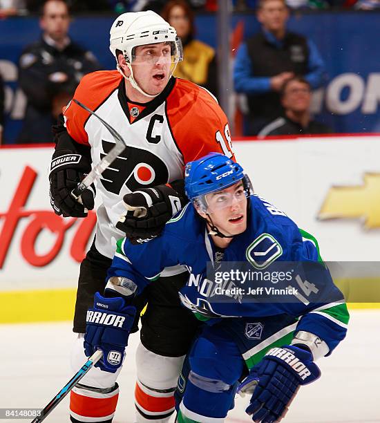 Alex Burrows of the Vancouver Canucks and Mike Richards of the Philadelphia Flyers look up-ice for the puck during their game at General Motors Place...