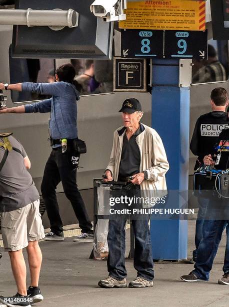 Film director Clint Eastwood stands on a platform of the Arras railway station, northern France, during the shooting of his new movie on September 1,...