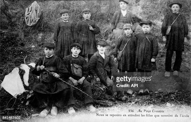 Carte postale illustrée par la photographie d'un groupe de jeunes garçons de la Creuse après l'école, en France.
