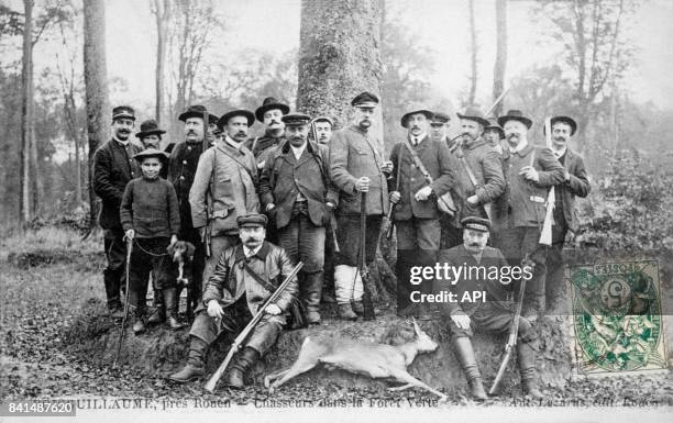 Carte postale illustrée par la photographie d'un groupe de chasseurs entourant une biche morte dans la Forêt Verte de Boisguillaume, près de Rouen,...