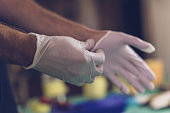 Male hands putting on latex gloves