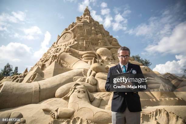 Representative from the Guinness Book of World Records Jack Brockba looks at his notes next to the Sandburg sandcastle on September 1, 2017 in...
