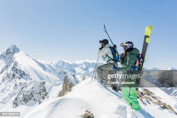 hombre y mujer en la cumbre de la montaña durante el día de esquí de travesía - orejeras fotografías e imágenes de stock