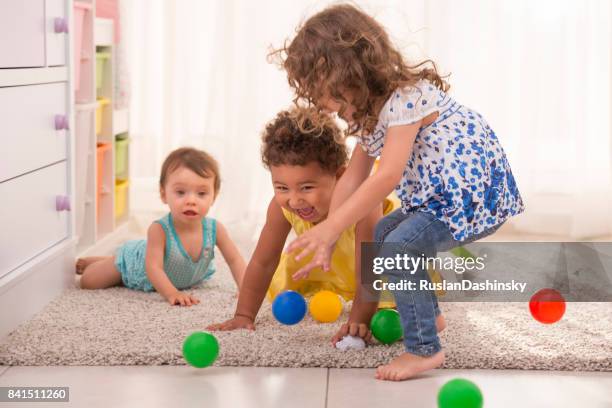 niñas jugando juntos en la sala de niños del árbol. - kids mess carpet fotografías e imágenes de stock