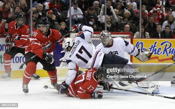 Cody Goloubef of Team Canada goes down on the ice as Ryan McDonagh of Team USA falls on top of him and Patrice Cormier of Team Canada and Thomas...