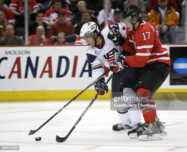 Cody Goloubef of Team Canada battles for the loose puck against Aaron Palushaj of Team USA during the IIHF World Junior Championships held at...