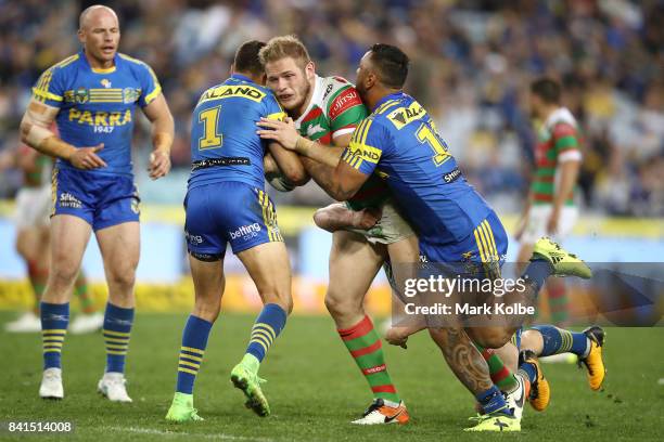 Tom Burgess of the Rabbitohs is tackled during the round 26 NRL match between the Parramatta Eels and the South Sydney Rabbitohs at ANZ Stadium on...