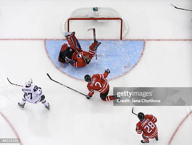 Dustin Tokarski of Team Canada makes a save against Drayson Bowman of Team USA as team mates Colten Teubert and Patrice Cormier of Team Canada look...