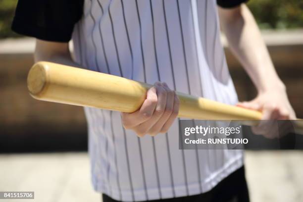 man holding a baseball bat - baseballschläger stock-fotos und bilder