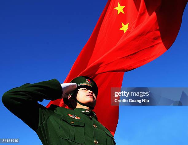 Paramilitary policeman does a national flag rising ceremony to mark the New Year before thousands of people climb the Great Wall on January 1, 2009...