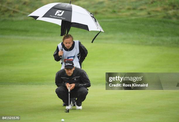 Jan Cafourek of the Czech Republic and his caddie lines up a putt on the 5th green during day two of the D+D REAL Czech Masters at Albatross Golf...