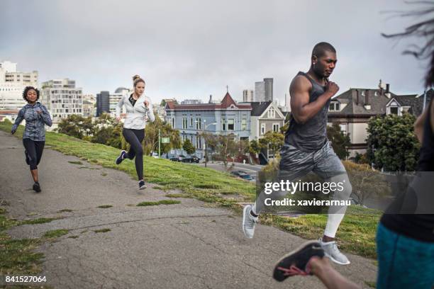 four people running on a park in san francisco - san francisco marathon stock pictures, royalty-free photos & images