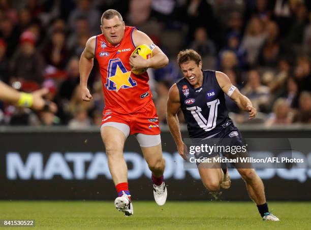 Scott Cummings of the All Stars is chased by Campbell Brown of Victoria during the 2017 EJ Whitten Legends Game between Victoria and the All Stars at...