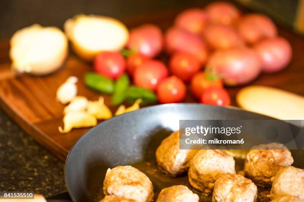 close-up of meatballs in frying pan on hot electric hob - brown bean stock pictures, royalty-free photos & images