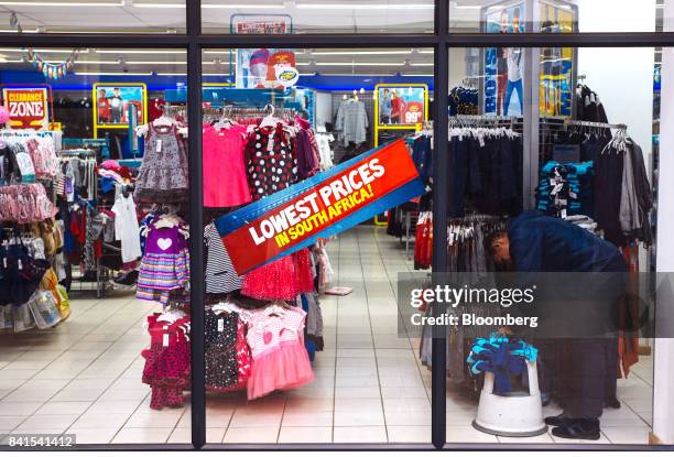 An employee stocks display hangars with children's clothing inside a PEP retail store, operated by Pepkor, a unit of Steinhoff International Holdings...