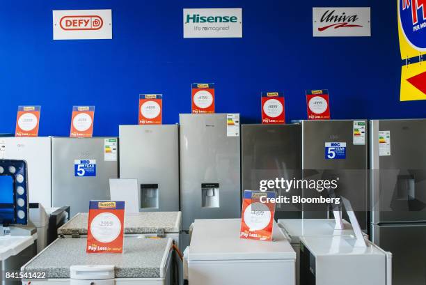 Water dispensers and white goods sit on display beside rand price signs inside a Russells furniture and electronics store, operated by Steinhoff...