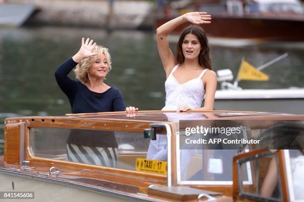 Brazilian model Isabeli Fontana and Italian designer Alberta Ferretti wave from a taxi-boat as they arrive at the Excelsior Hotel during the 74th...