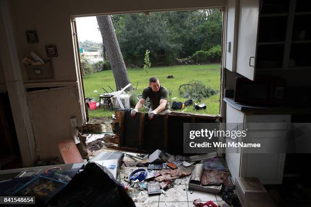 Derek Pelt removes a portion of his friend Bryan Parson's home while helping to remove damage caused by flooding brought on by Hurricane Harvey...