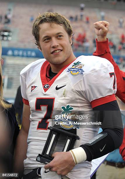 Quarterback Matthew Stafford of the University of Georgia holds the most valuable player trophy after play against the Michigan State Spartans during...