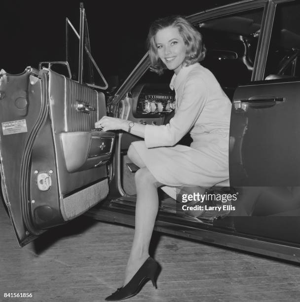 English Actress Honor Blackman smiles while coming out from a car, UK, 26th March 1964.