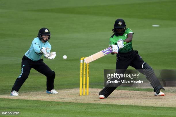 Stafanie Taylor of Western Storm cracks a boundary as wicket keeper Tammy Beaumont of Surrey Stars looks on during the Women's Kia Super League Semi...
