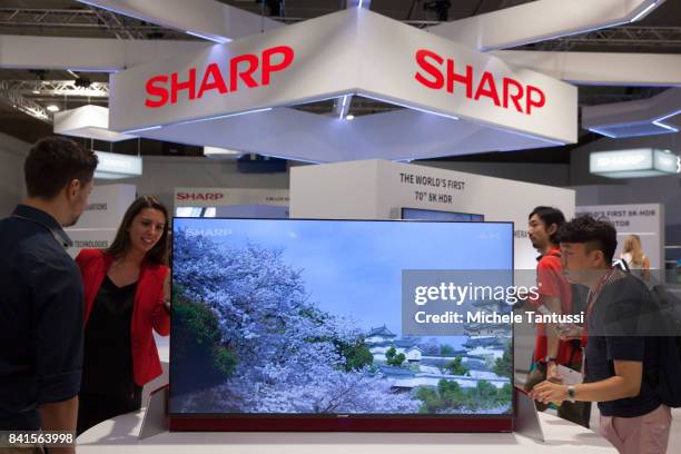 Visitors try out Sharp TV Screens at the Sharp stand at the 2017 IFA consumer electronics and home appliances trade fair on September 1, 2017 in...