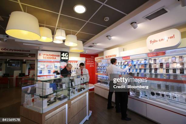 Employees serve customers inside a Mobile TeleSystems PJSC mobile communications store in Moscow, Russia, on Friday, Sept. 1, 2017....