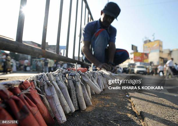 Sri Lankan people prepare to light fire crackers in Colombo on January 02 to celebrate the military capturing the northern town of Kilinochchi on...