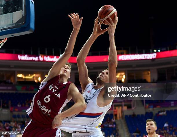 Serbia's center Ognjen Kuzmic vies for the ball with Latvia's power forward Kristaps Porzingis during the FIBA Eurobasket 2017 men's group D...