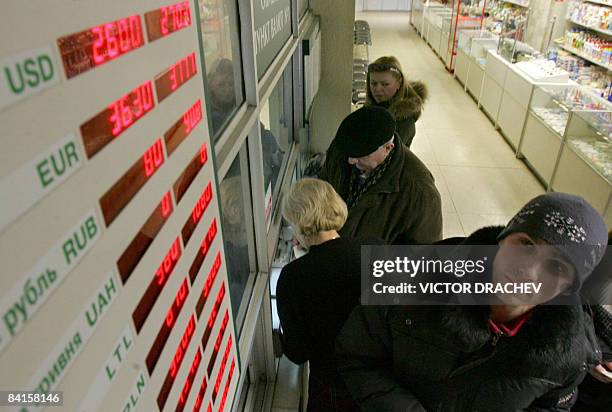 Belarus man stands near a currency exchange point in Minsk on January 2, 2009. Belarus on Friday devalued its ruble by more than a fifth against the...