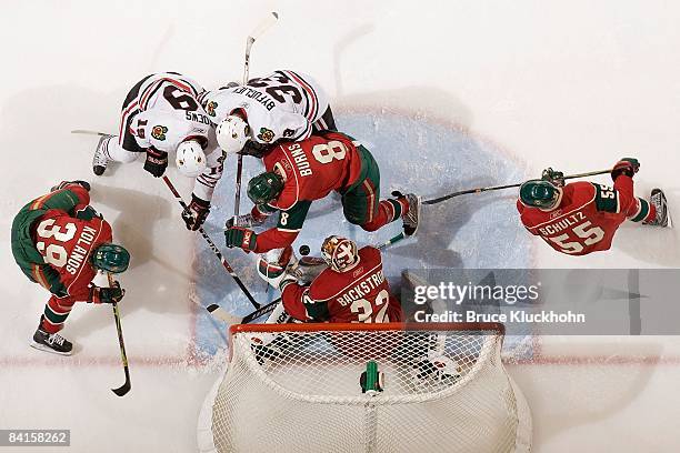 Niklas Backstrom, Krys Kolanos, Nick Schultz and Brent Burns of the Minnesota Wild defend their goal against Dustin Byfuglien and Jonathan Toews of...