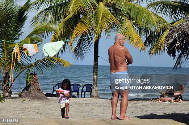 Tourists visit the private beach of Playa Blanca, about 12 km northwest of Livingston in Guatemala's tiny slice of Caribbean coastline on December...