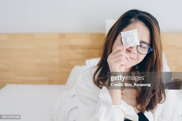 cropped shot view of asian women holding condom in her hand. - condoms imagens e fotografias de stock