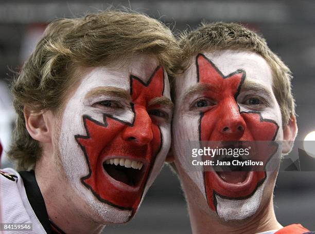 Fans of Team Canada with a Canadian flag painted on their faces yell during the Team Canada game against Team USA during the 2009 IIHF World Junior...