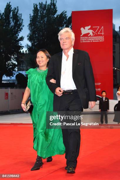 Christopher Doyle and guest walk the red carpet ahead of the 'Human Flow' screening during the 74th Venice Film Festival at Sala Grande on September...