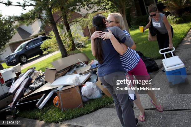 Dickinson resident hugs a friend who came to help her remove possessions damaged by flooding brought on by Hurricane Harvey September 1, 2017 in...