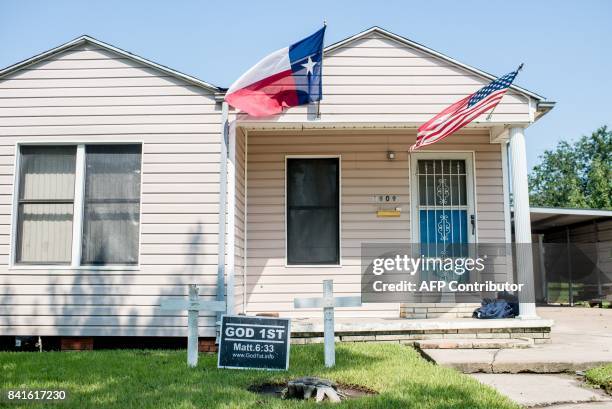 House with the US and Texas state flag is seen in Port Arthur, Texas on September 1, 2017. Houston was limping back to life on Friday one week after...