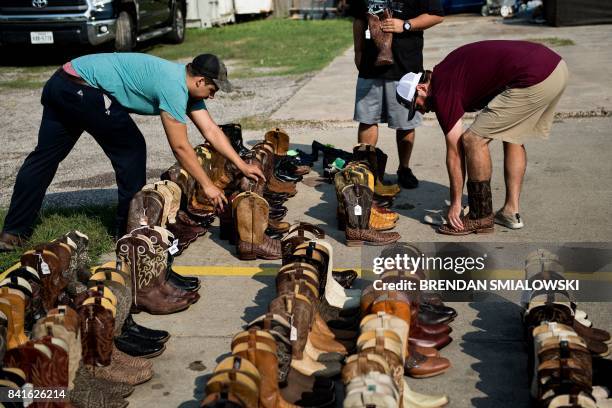 People look for good deals on salvaged custom cowboy boots at Jesse's Shoe Repair as residents begin the recovery process from Hurricane Harvey on...